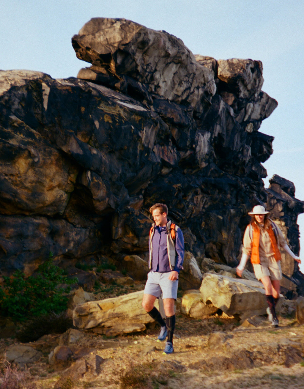 A man and woman are hiking on rocks.