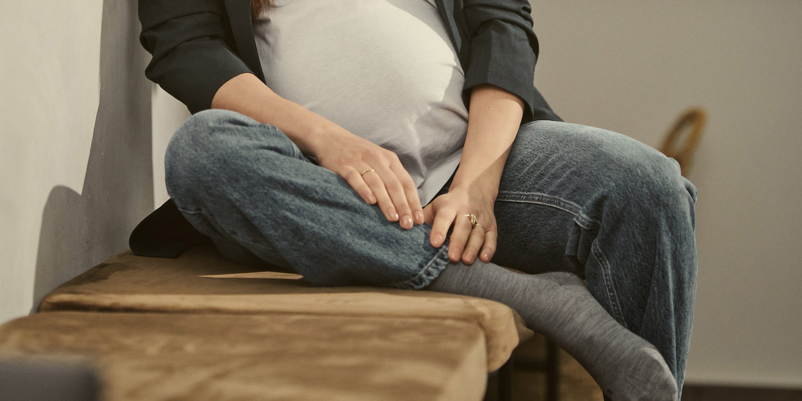 Pregnant woman sitting on a wooden bench.