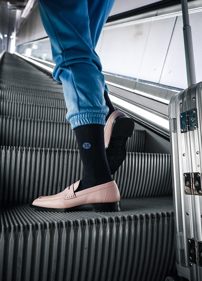 Person standing on roller skates with a suitcase.