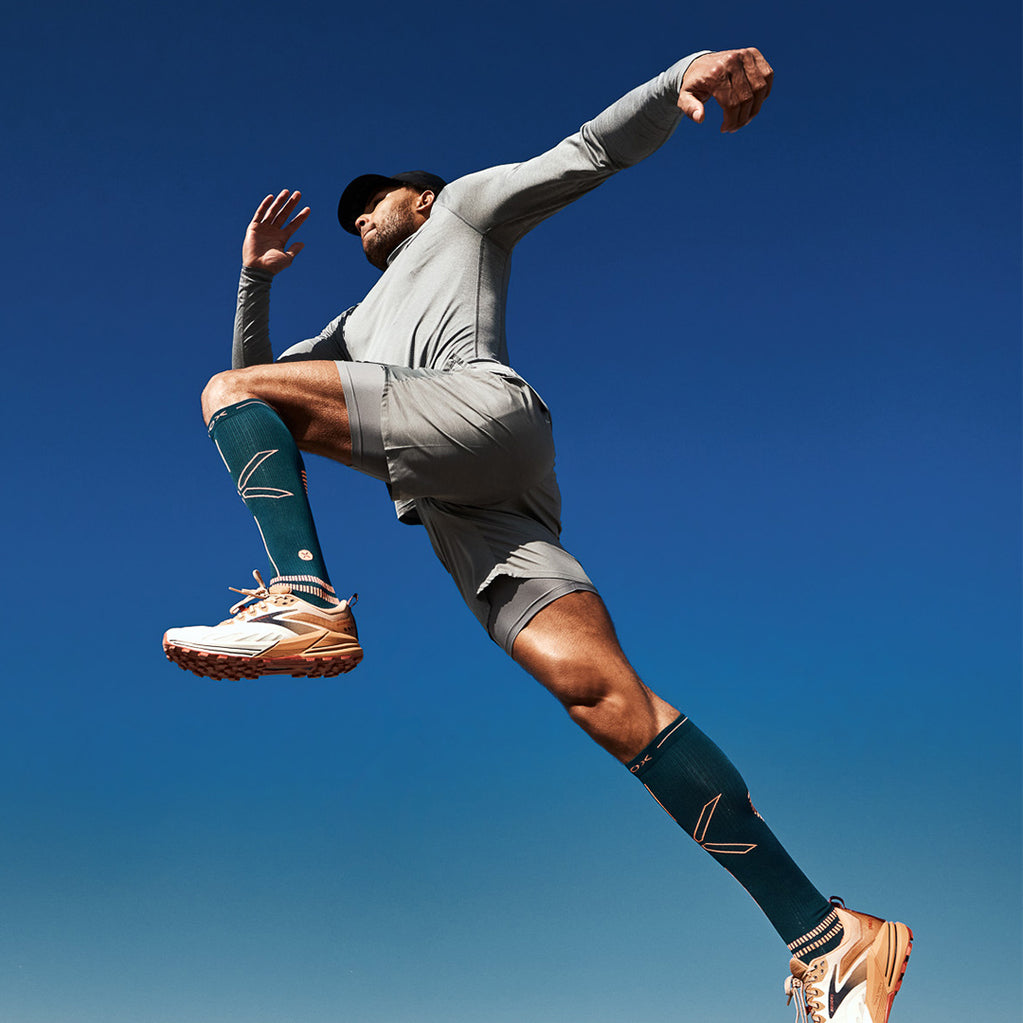 Jumping man with blue skies behind him. 