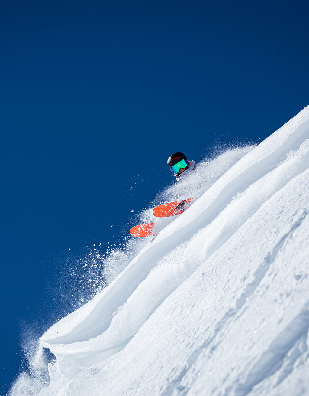 Skier in the snow with orange skis.