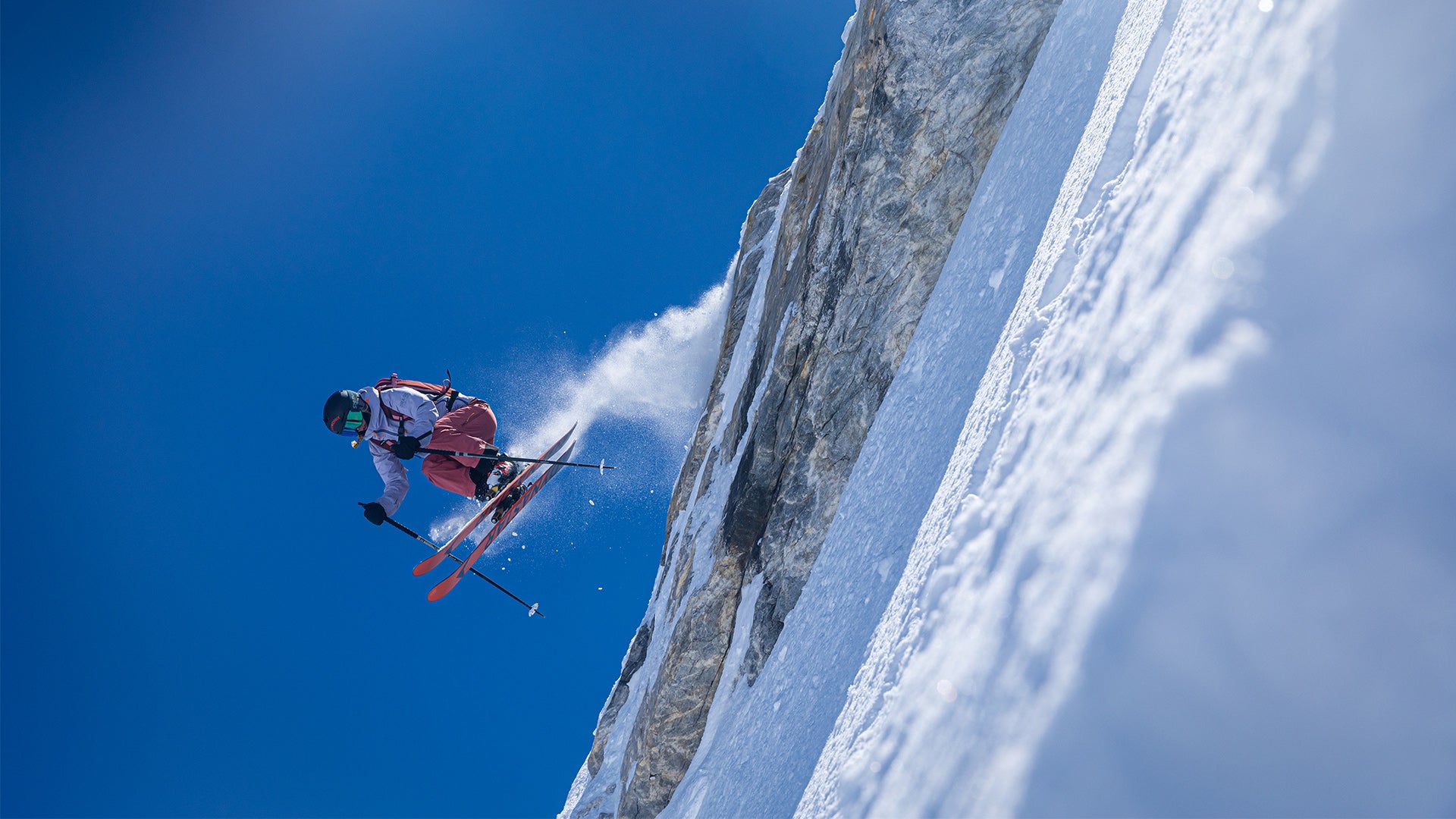 Skier jumping off the slope with a blue sky.