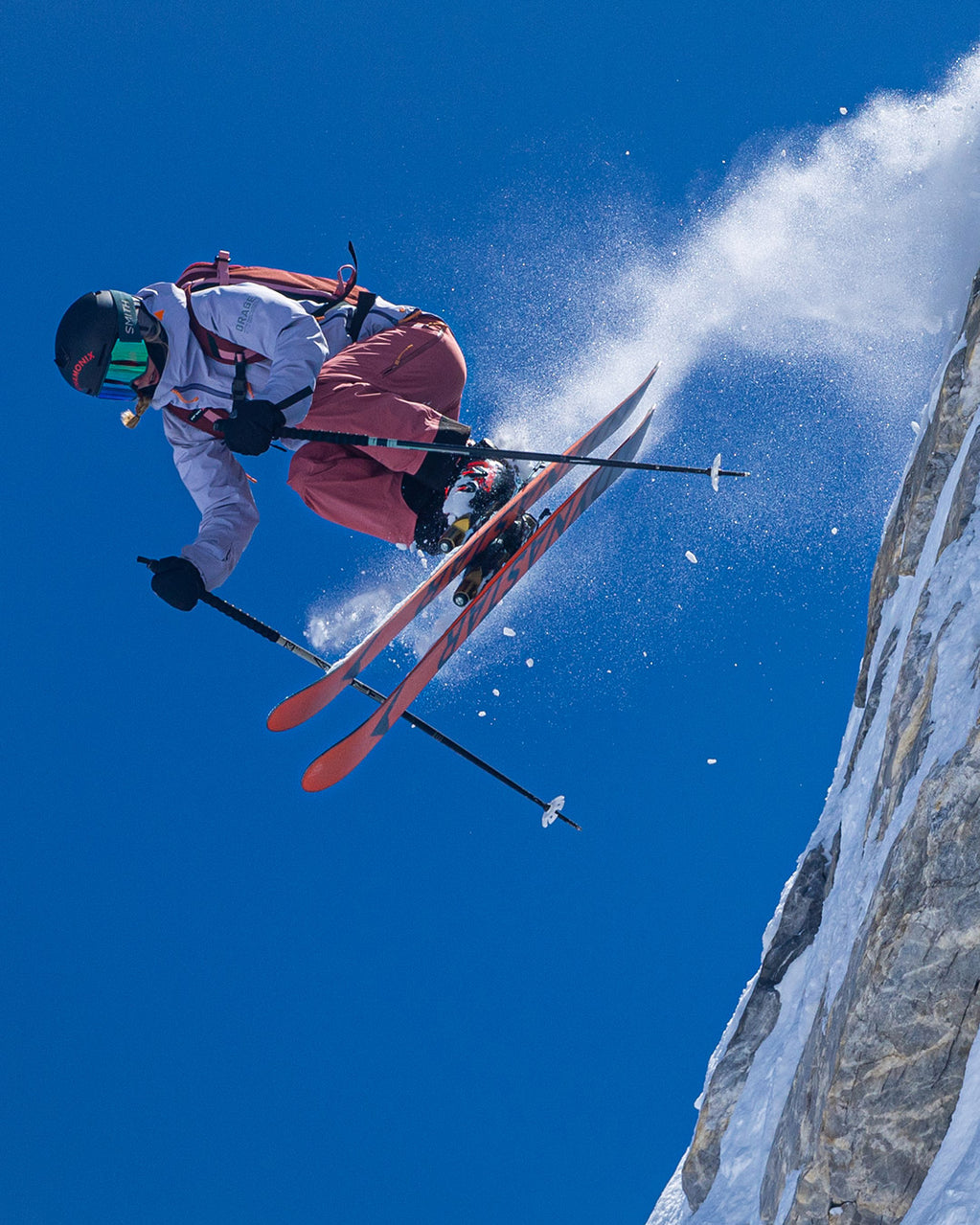 Skier jumping off the slope with a blue sky.