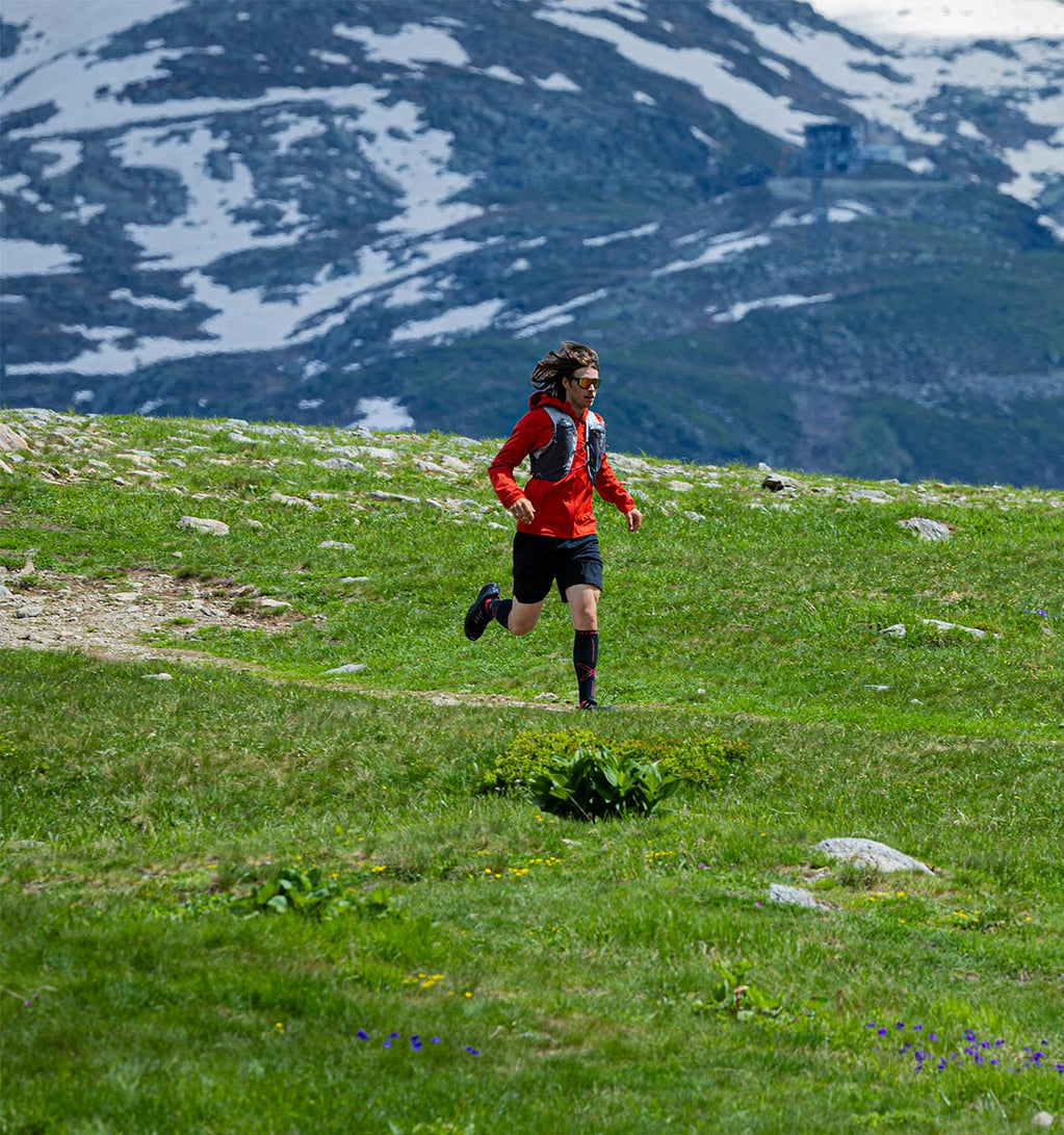 Men running on a field of grass.