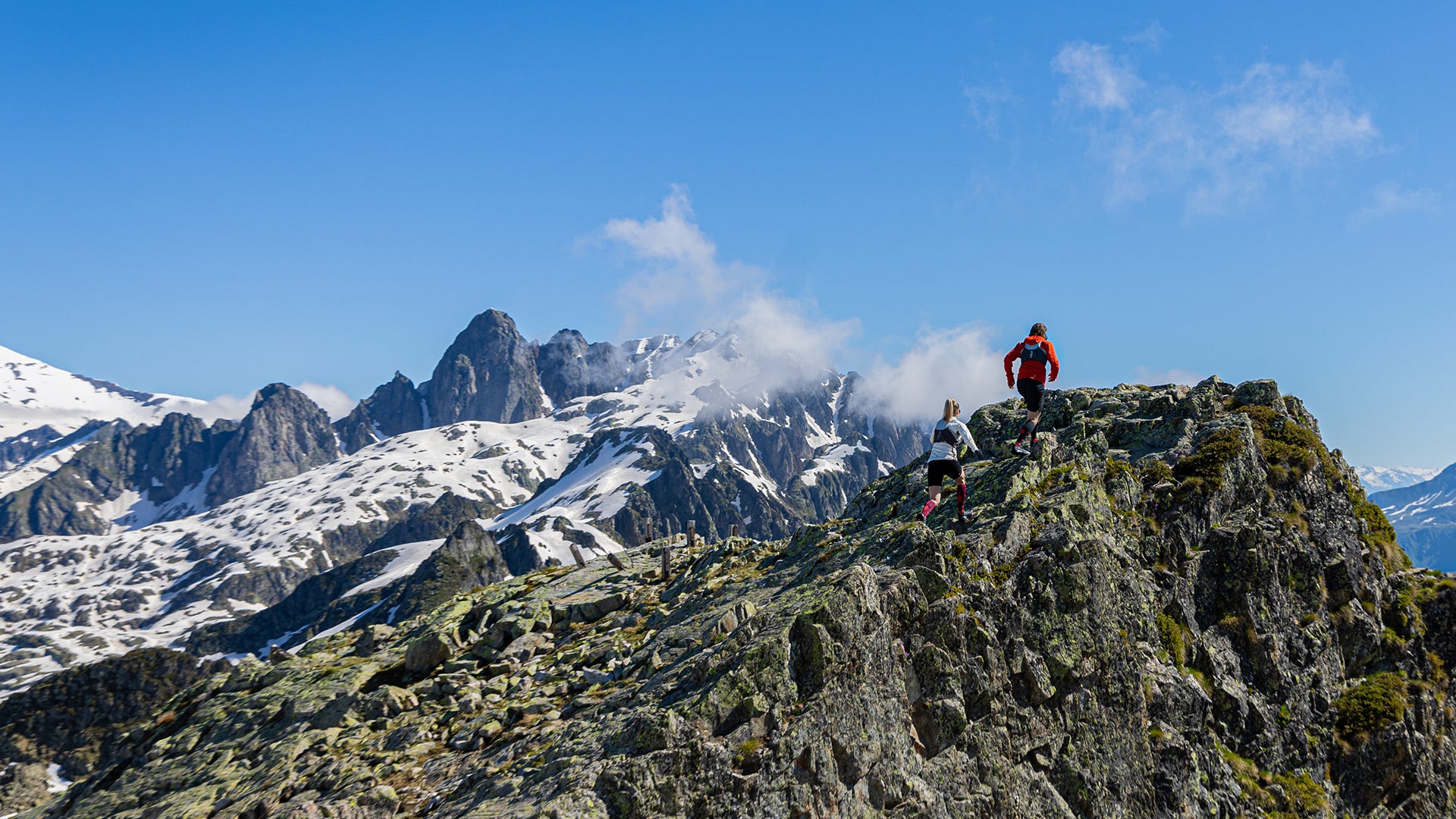 Couple running in the mountains on rocks.