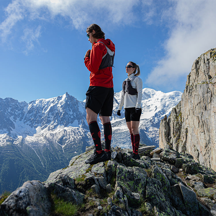 Couple standing on rocks in the mountains.