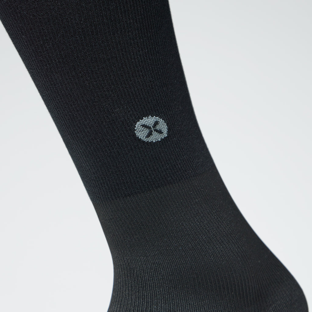 Close up of a black compression sock with a logo. 