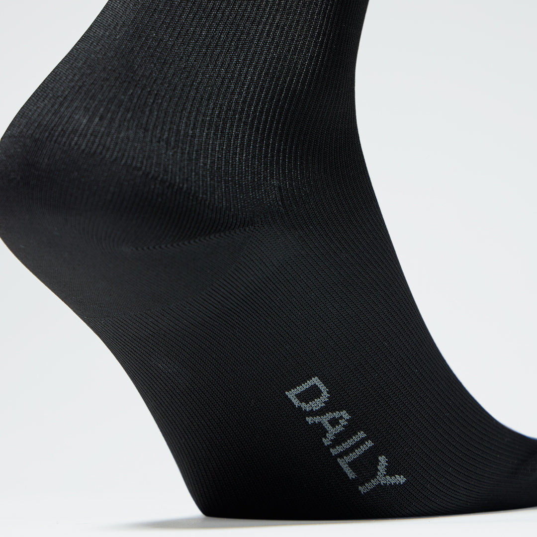 Close up of a black compression sock with text.