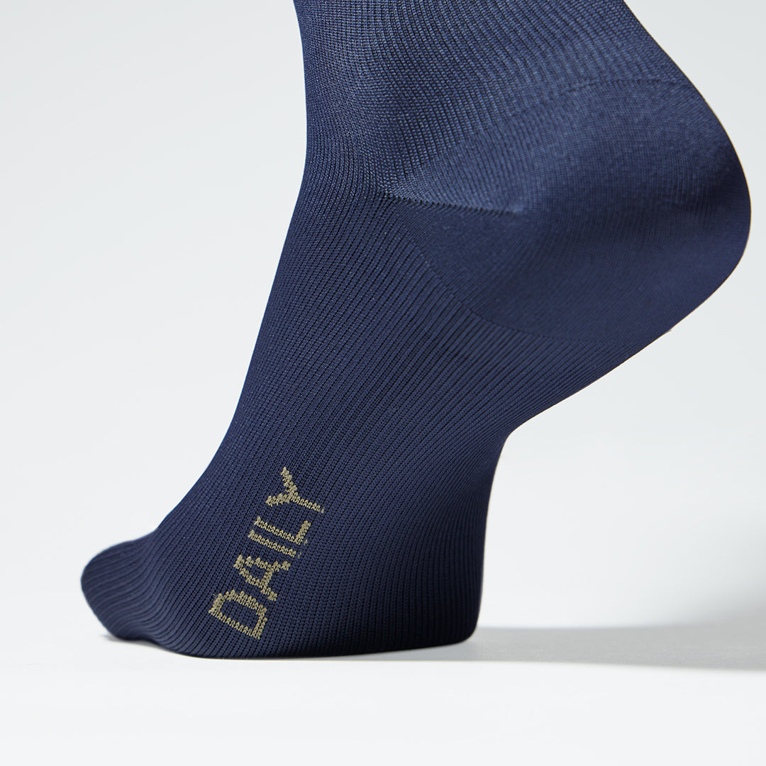 Close up of a navy compression sock with text. 