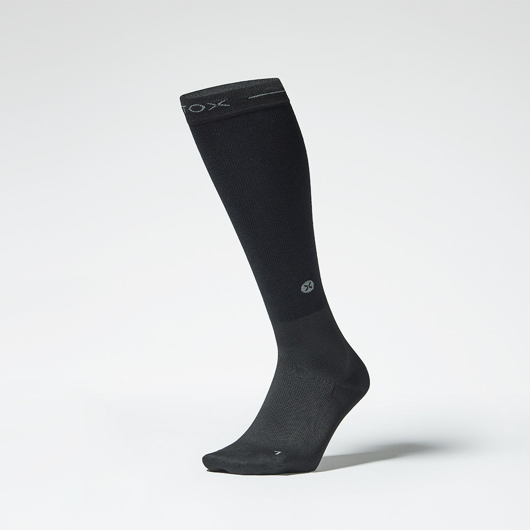 Front view of a black compression sock.