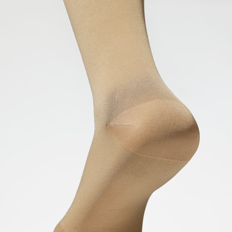 Detailed view of a medical thigh high stocking in a sand color. 