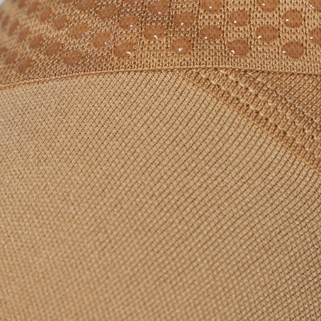 Detailed view of a medical thigh high stocking in a sand color. 