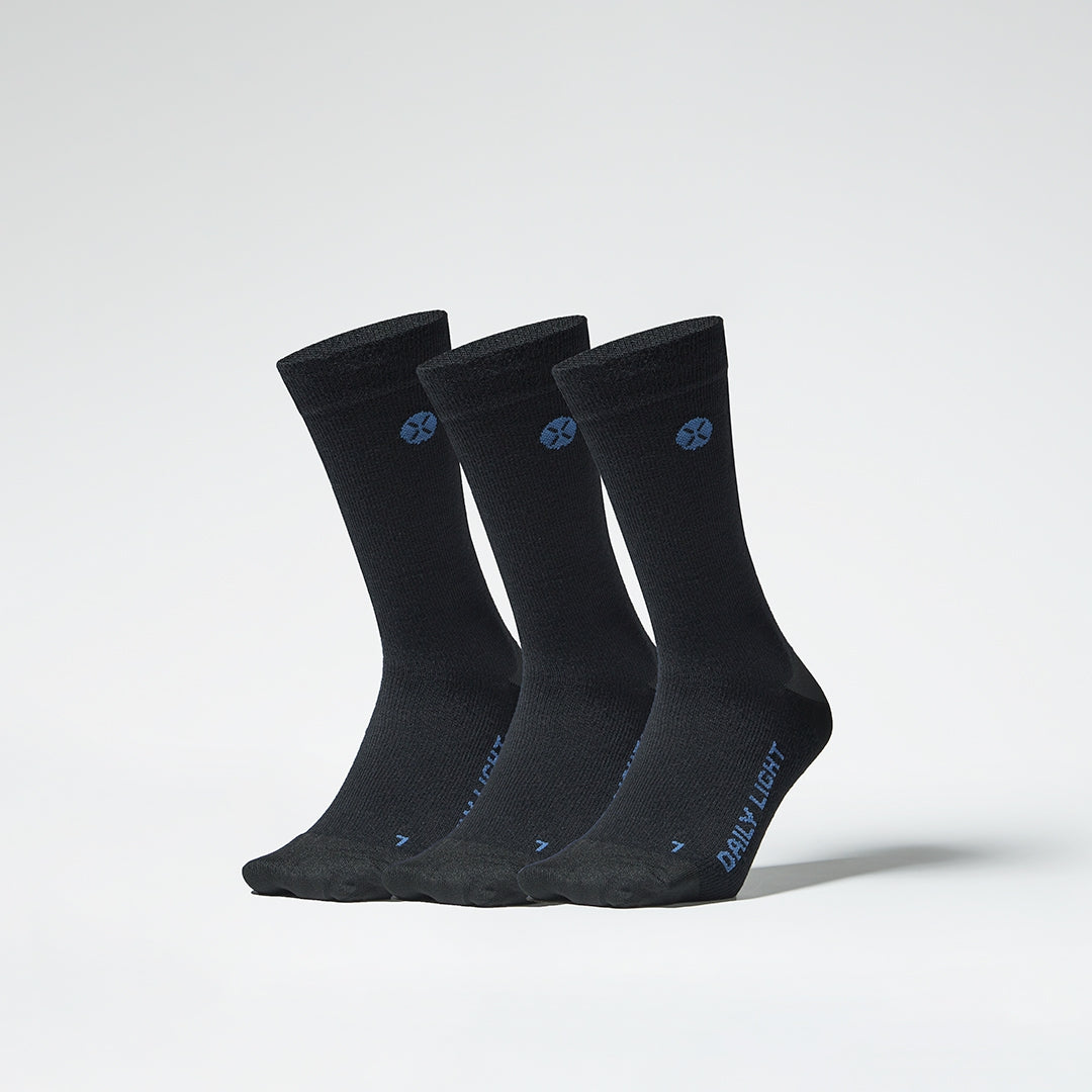 A three pack of black mid calf compression socks from the front.