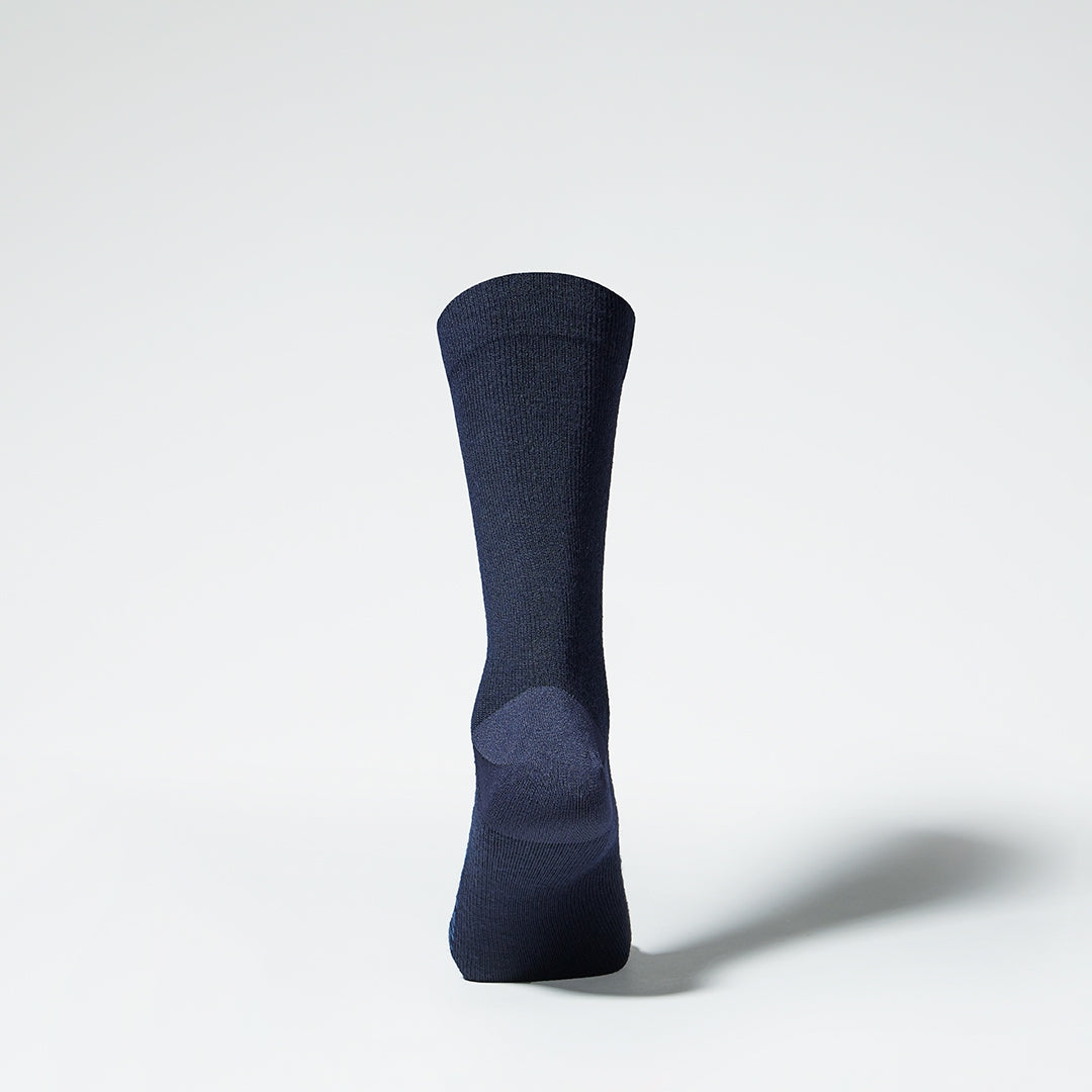 A dark blue mid calf compression sock from the back.