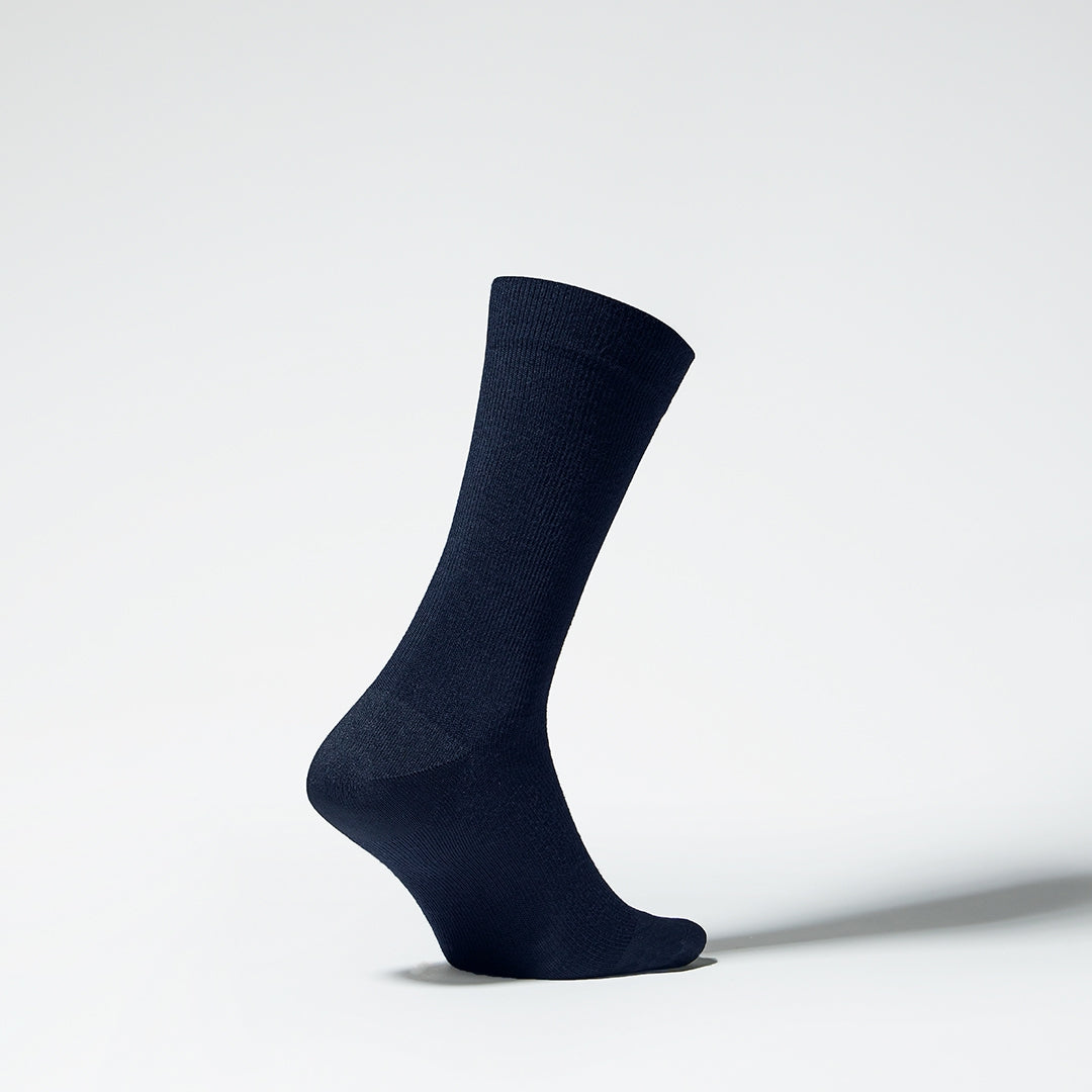 A dark blue mid calf compression sock from the side.