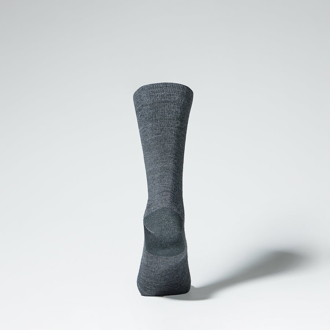 A grey mid calf compression sock from the back.