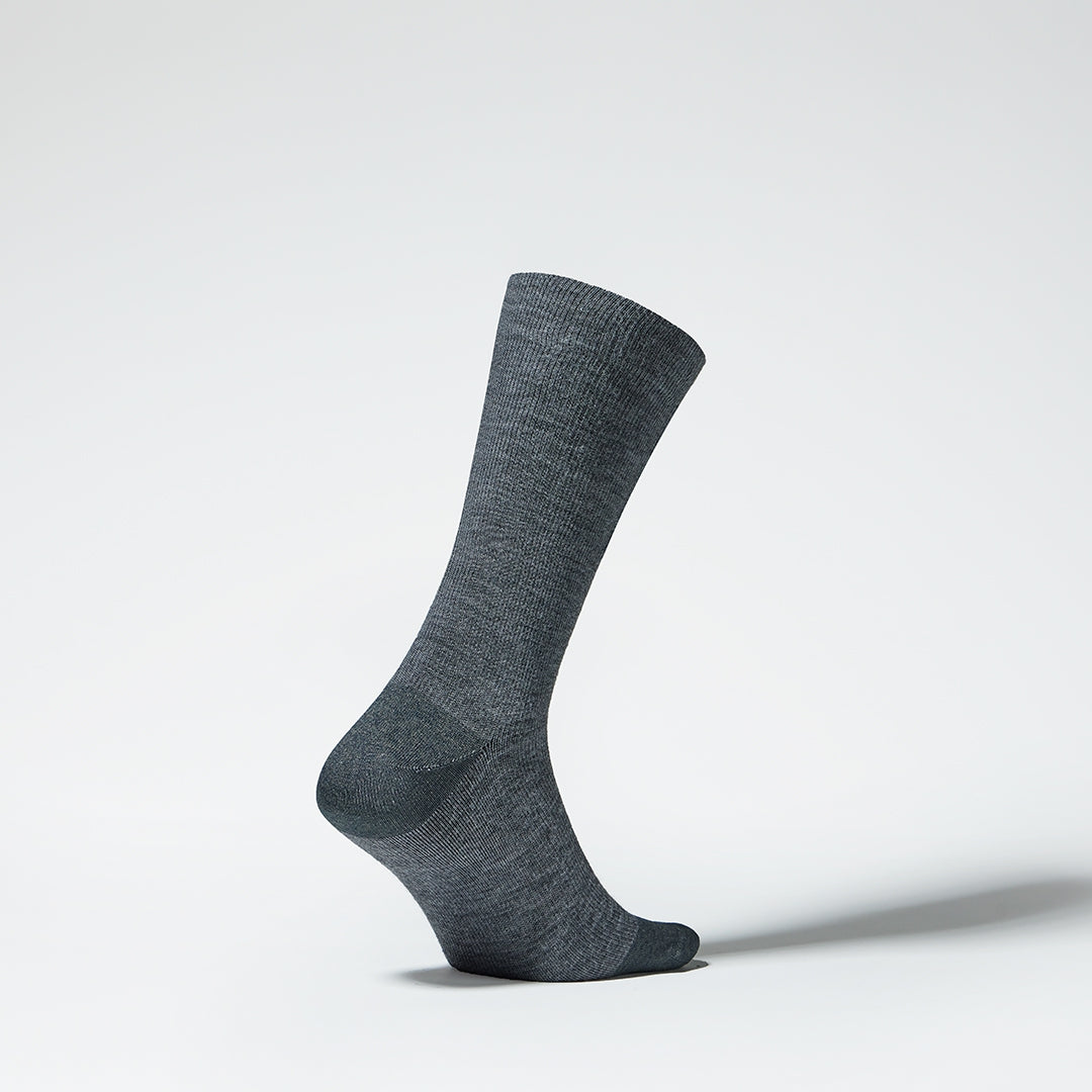 A grey mid calf compression sock from the side.