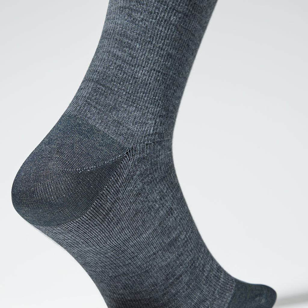 A close up of a grey mid calf compression sock.