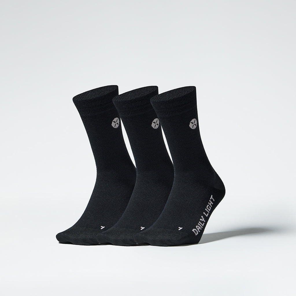 Front view of three mid-calf black compression socks.