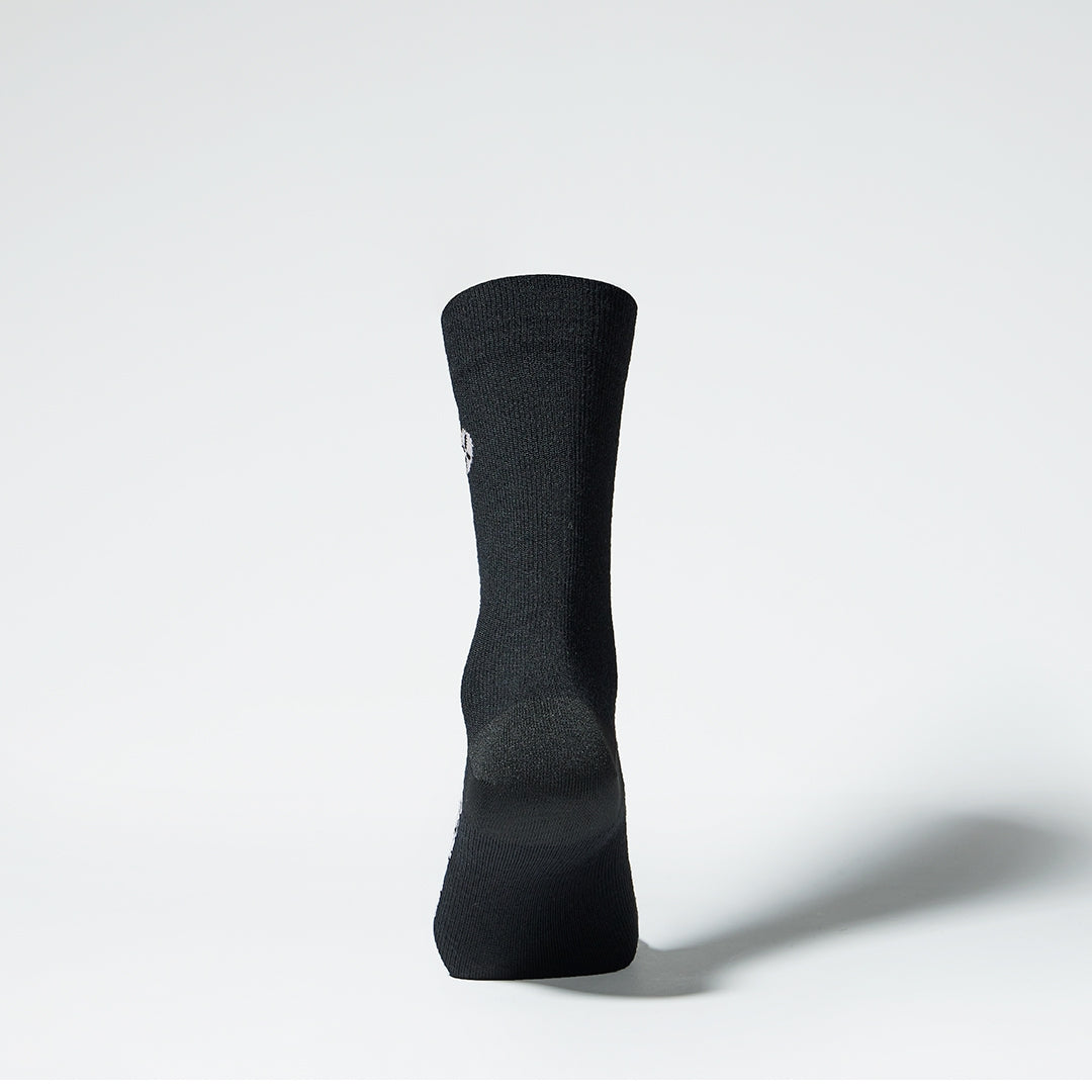 Back view of a mid-calf black compression sock.