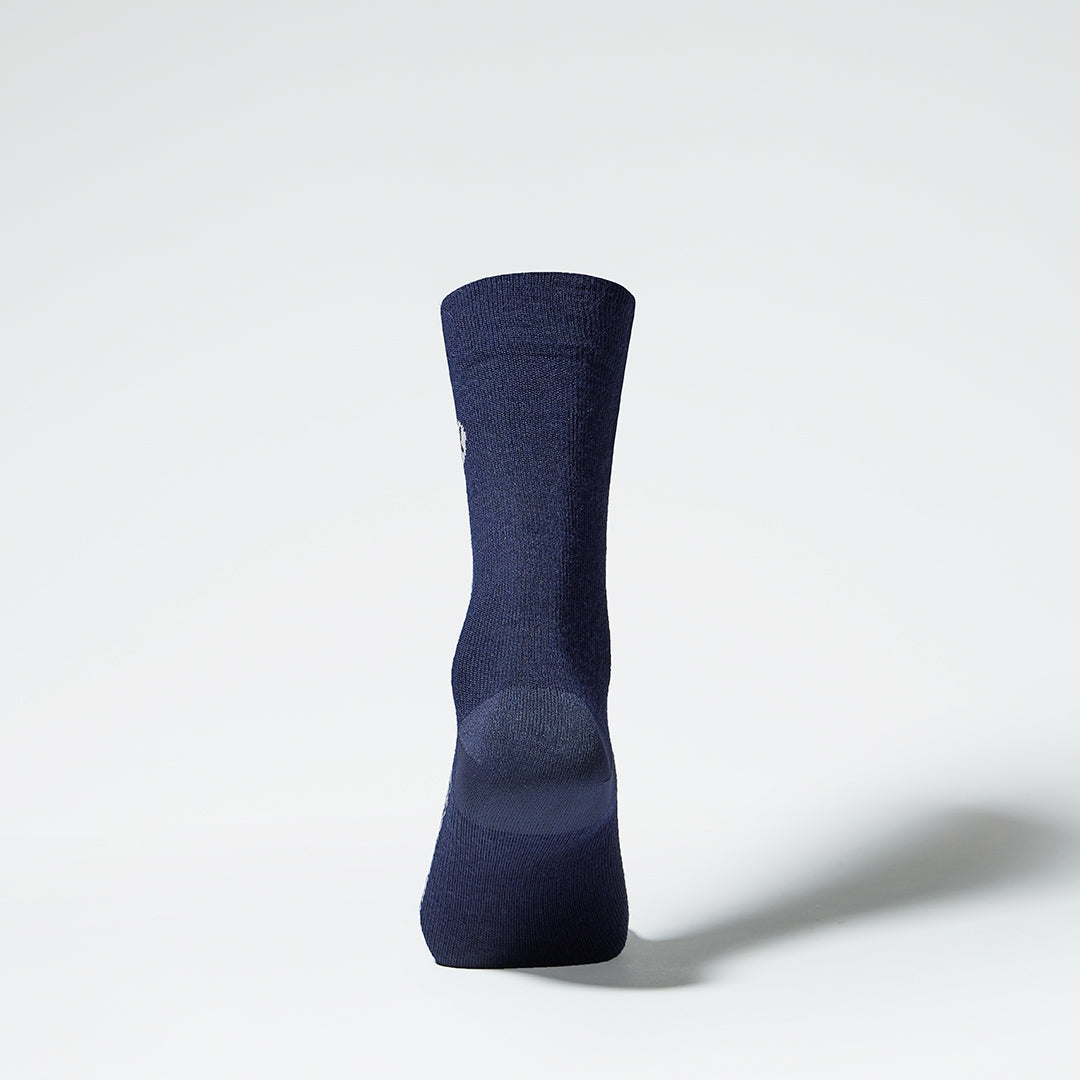 Back view of a mid-calf dark blue compression sock.