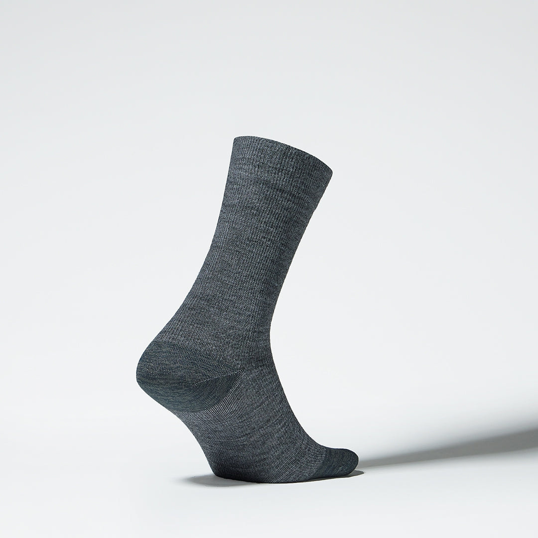Side view of a mid-calf grey compression sock.