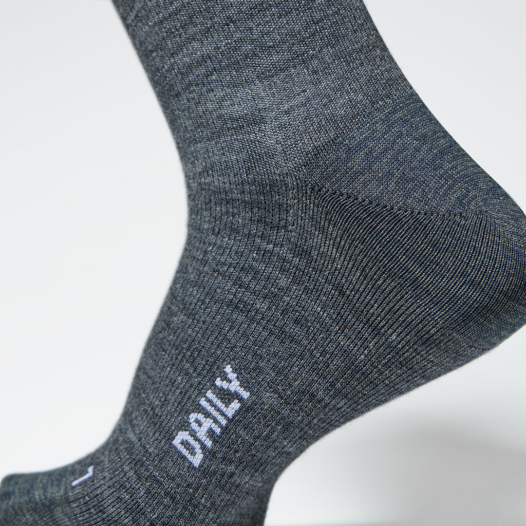 A close up of a dark grey compression sock with white text.