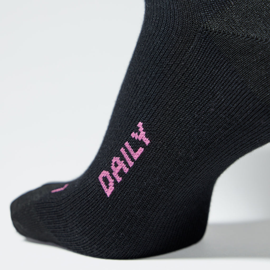 A close up of a black compression sock with fuchsia text on it.