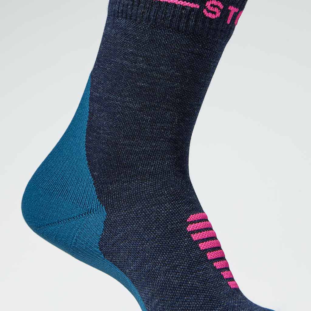 Close up of a dark blue ankle high compression sock with pink details.