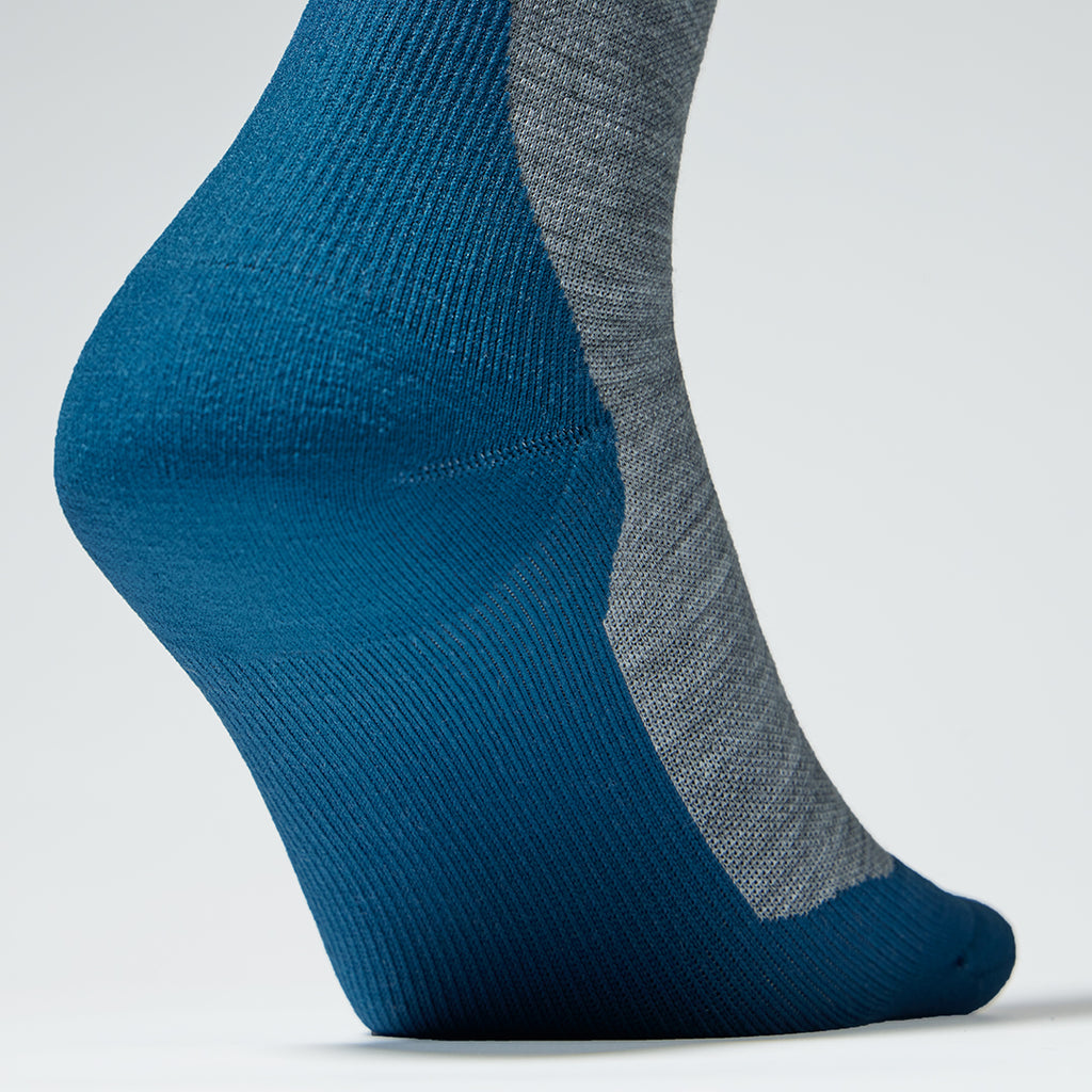 Detailed view of a grey ankle compression socks with teal details. 
