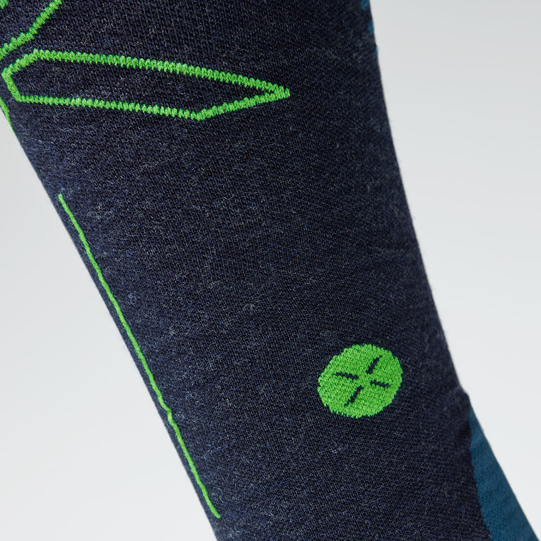 Close up of a dark blue compression sock with a green logo.