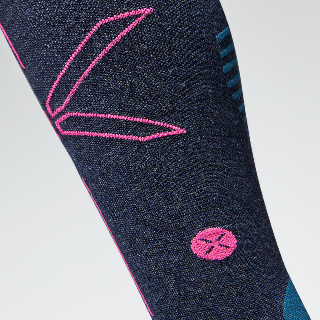 Close up of a dark blue compression sock with a pink coloured logo. 
