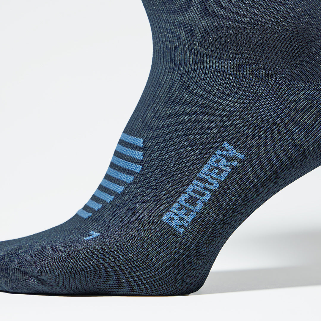 Detailed view of a blue knee high compression sock with blue details.