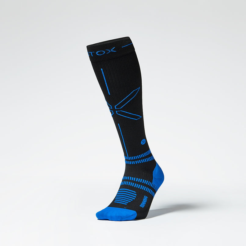 A knee high compression sock in black with blue details from the front.