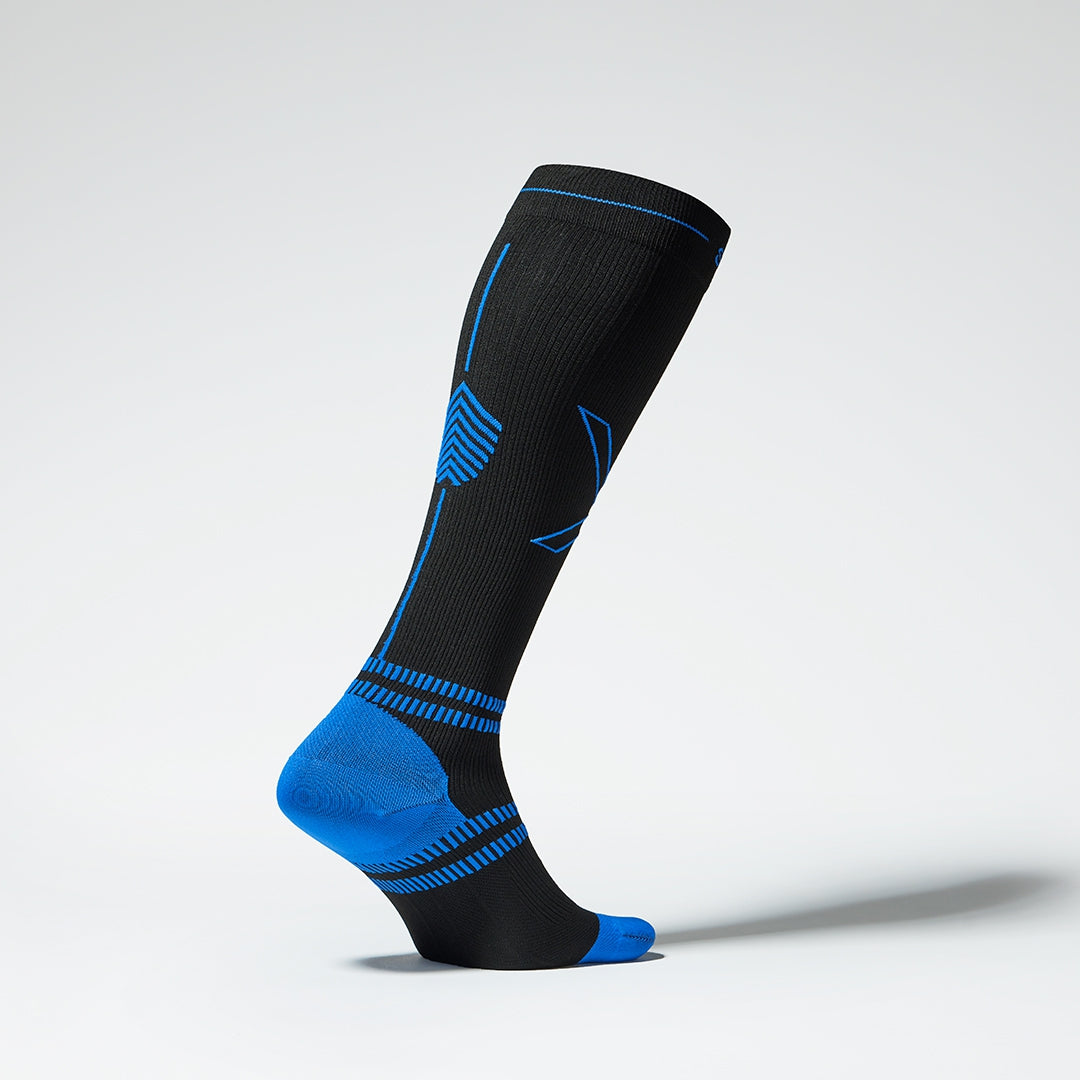 Side view of a black knee high compression sock with blue accents.