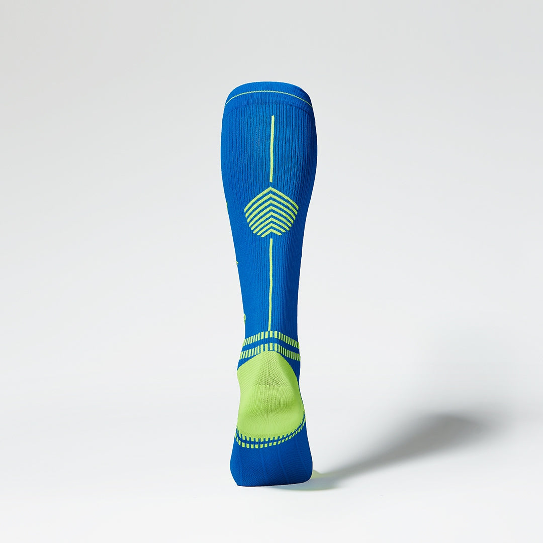 Blue knee high compression sock with yellow details from the back.