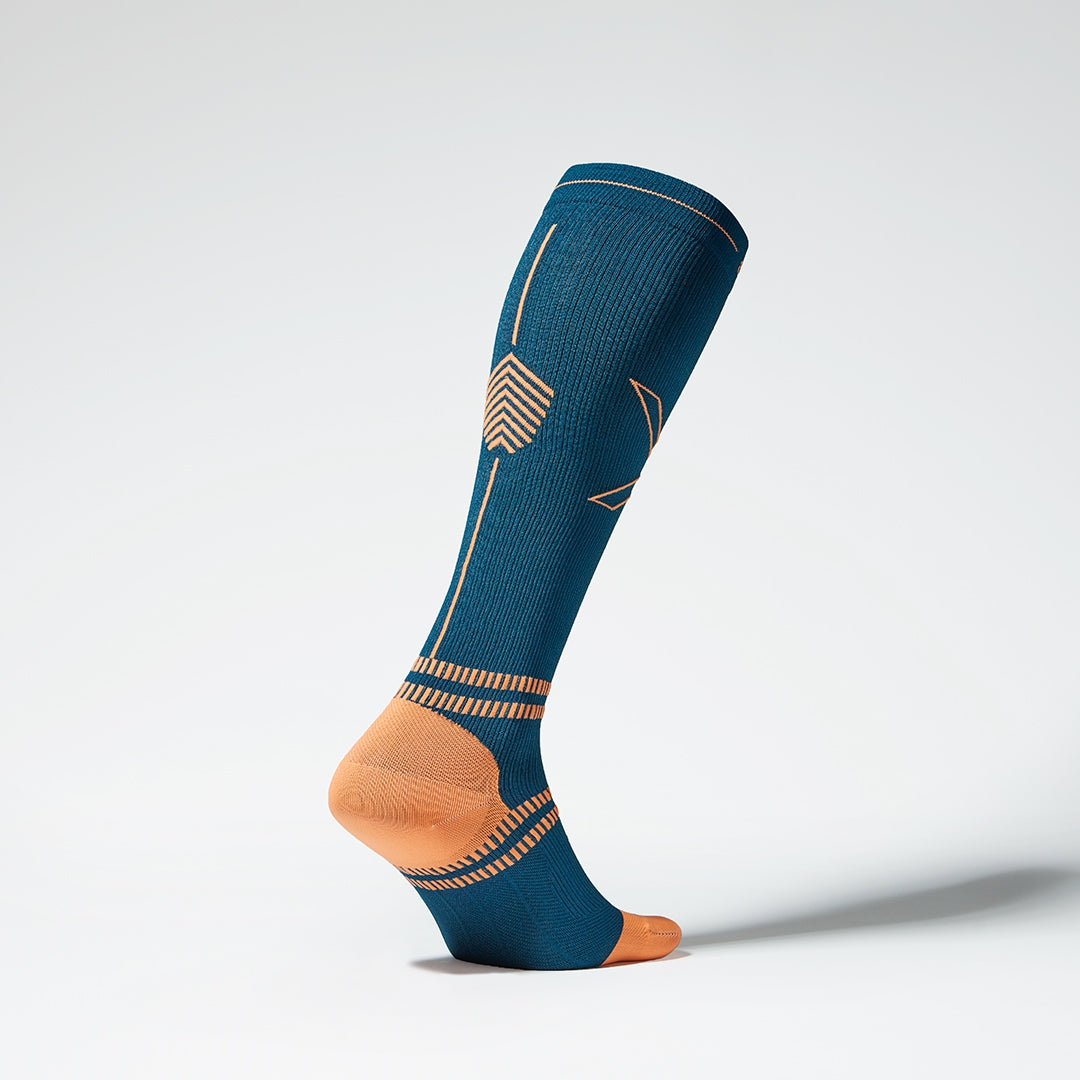 Side view of a knee high compression sock in regatta blue. 