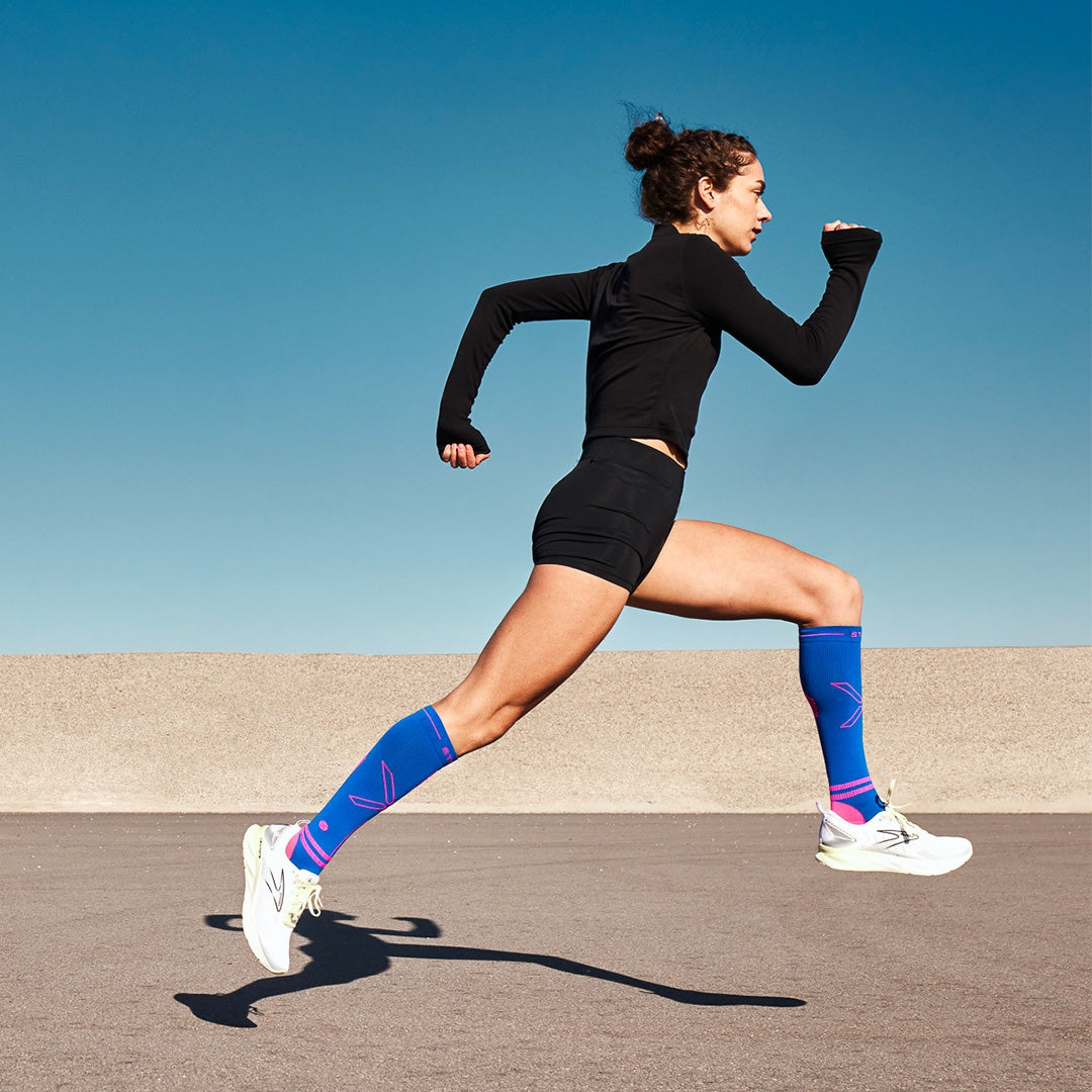 Running woman wearing bright blue socks.