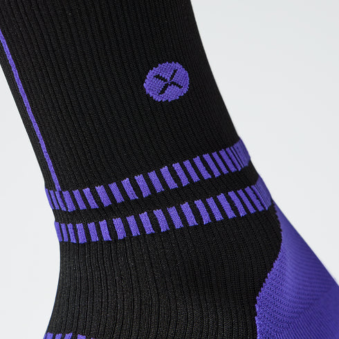 Close up of toes in a black compression sock with purple accents. 