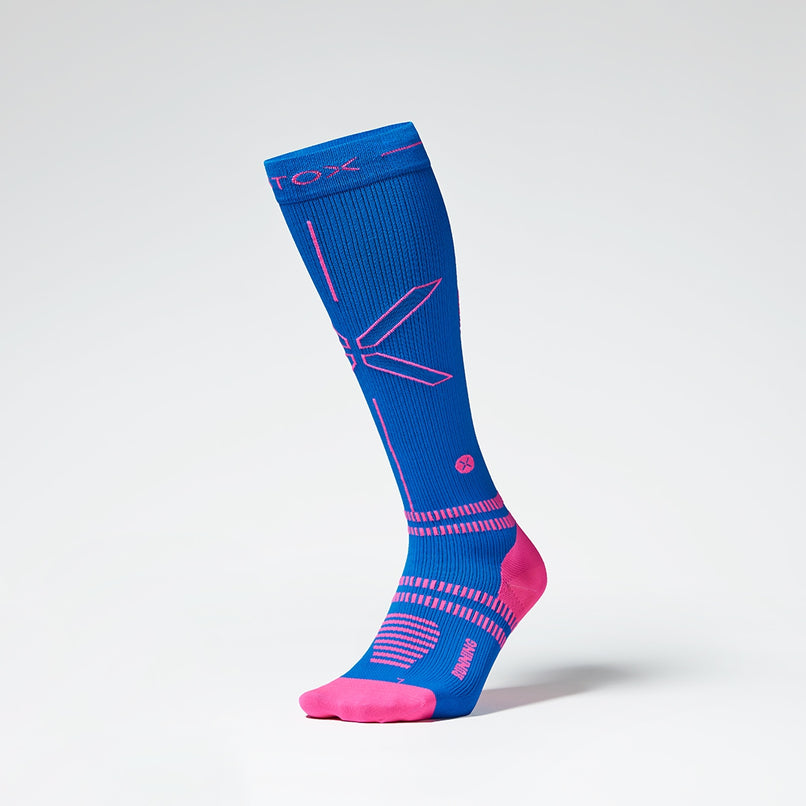 Front view of a blue colored knee high compression sock with pink accents. 