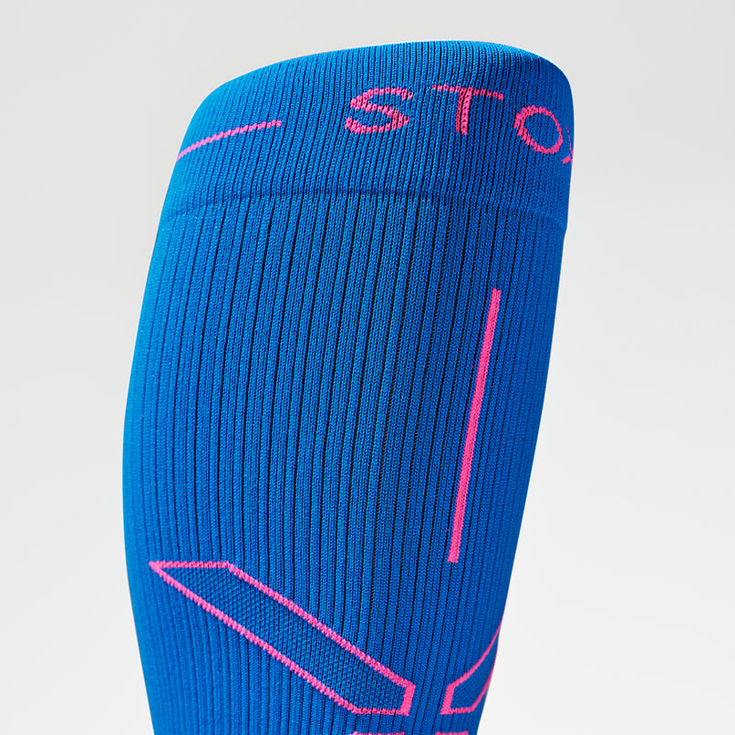 Close up of toes in a blue compression sock with pink accents. 