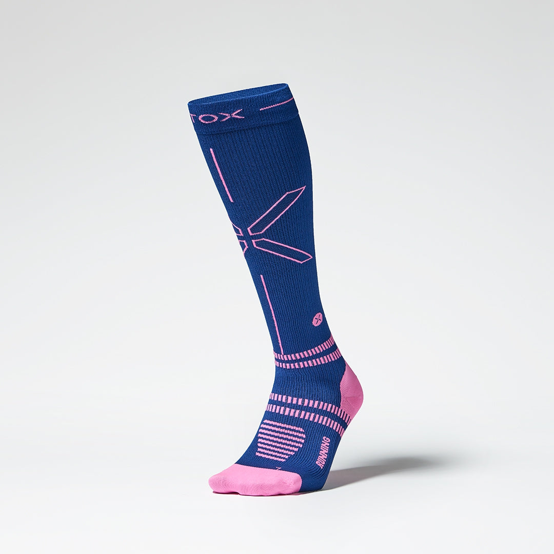 Side view of a dark blue colored knee high compression sock with pink accents. 