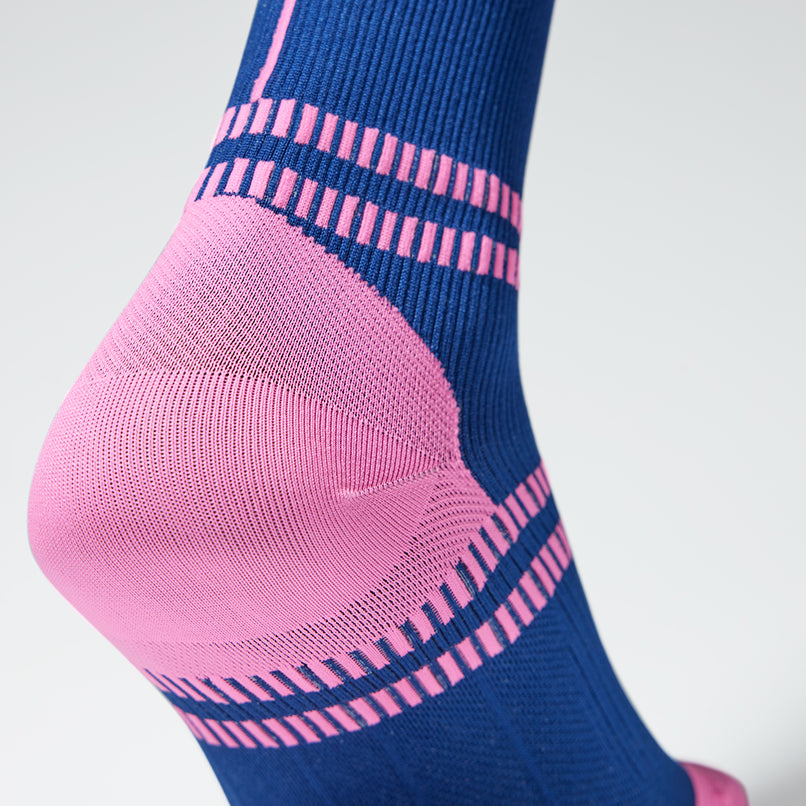Close up of toes in a dark blue compression sock with pink accents. 