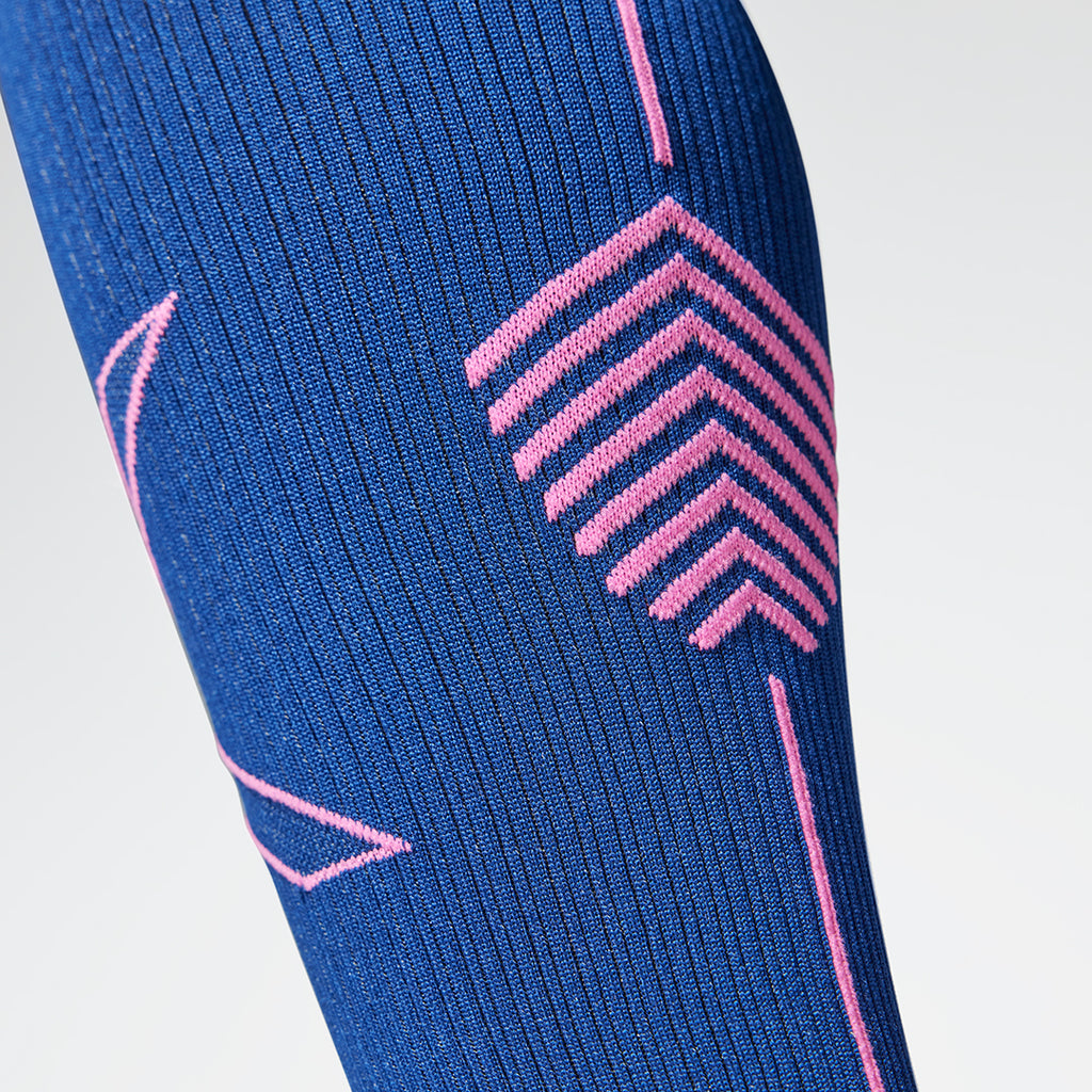 Close up of a dark blue colored compression sock with a pink logo. 