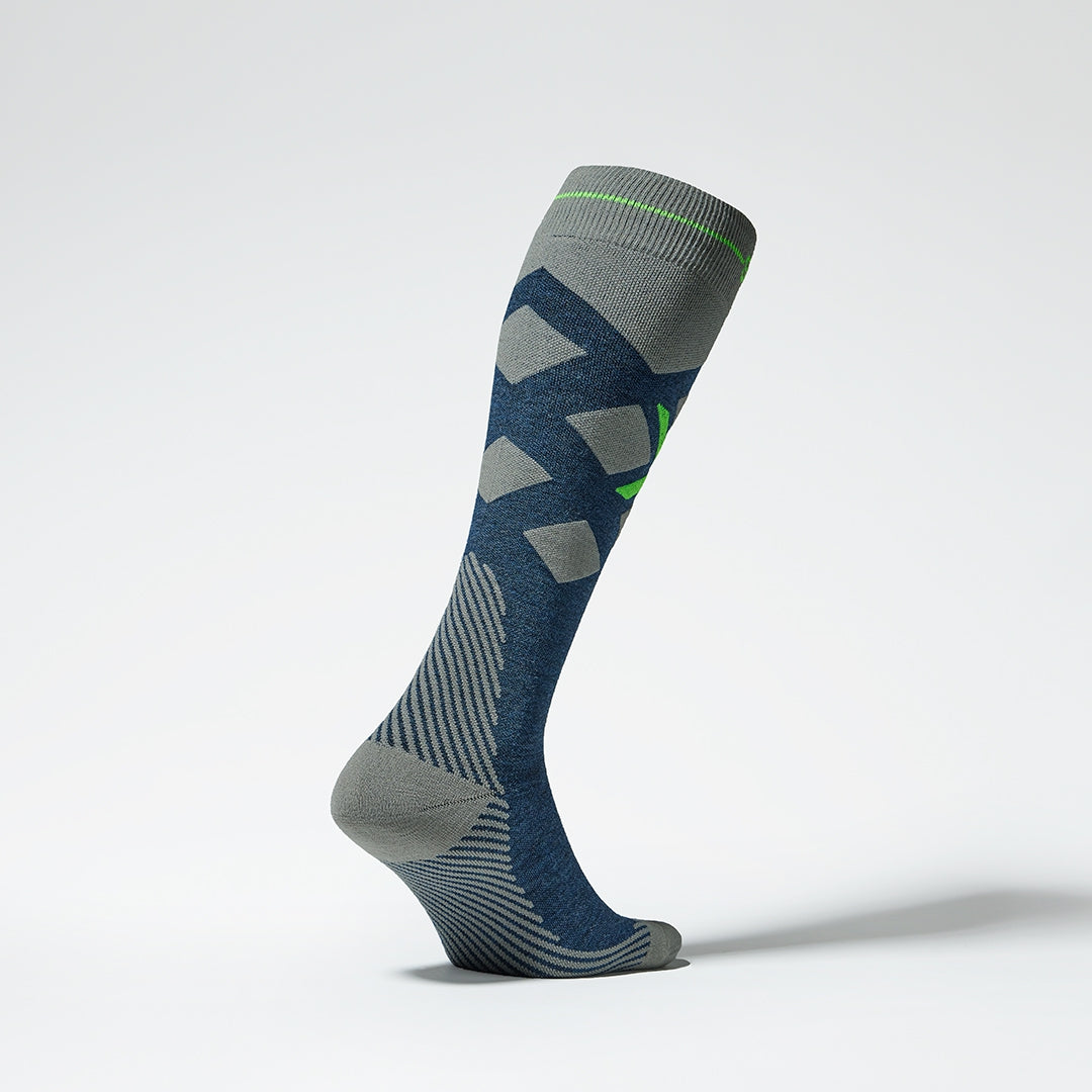 Side view of grey blue compression socks with green details.