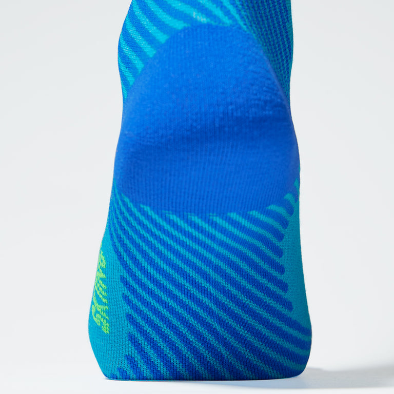 Close up of a compression sock in turquoise with a cobalt heel. 
