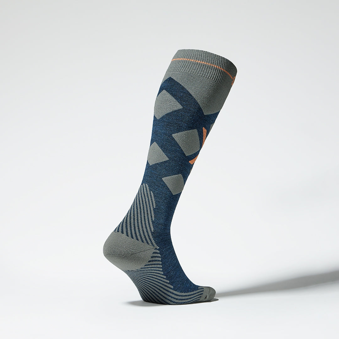 Side view of a blue grey compression skiing socks with orange details.