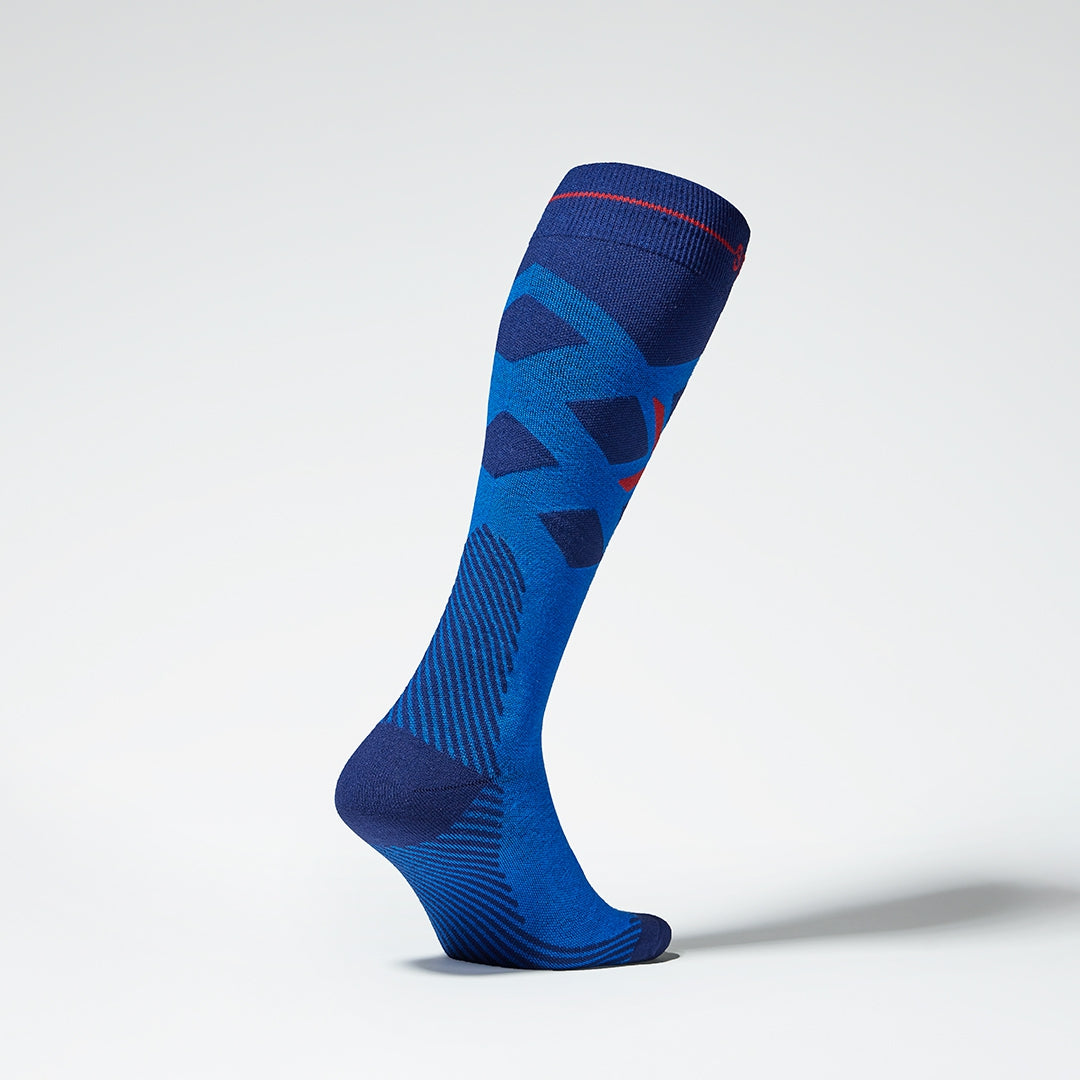 Side view of a cobalt compression skiing socks with red details.