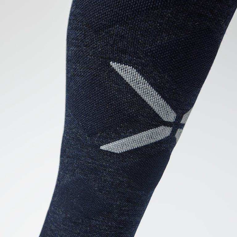 Close up of a navy high compression sock with a grey logo.