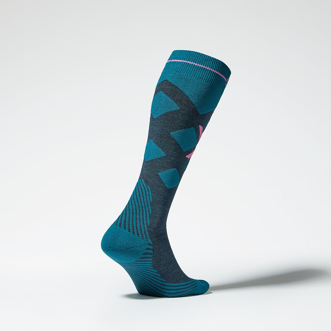 Side view of a teal compression skiing socks with pink details.